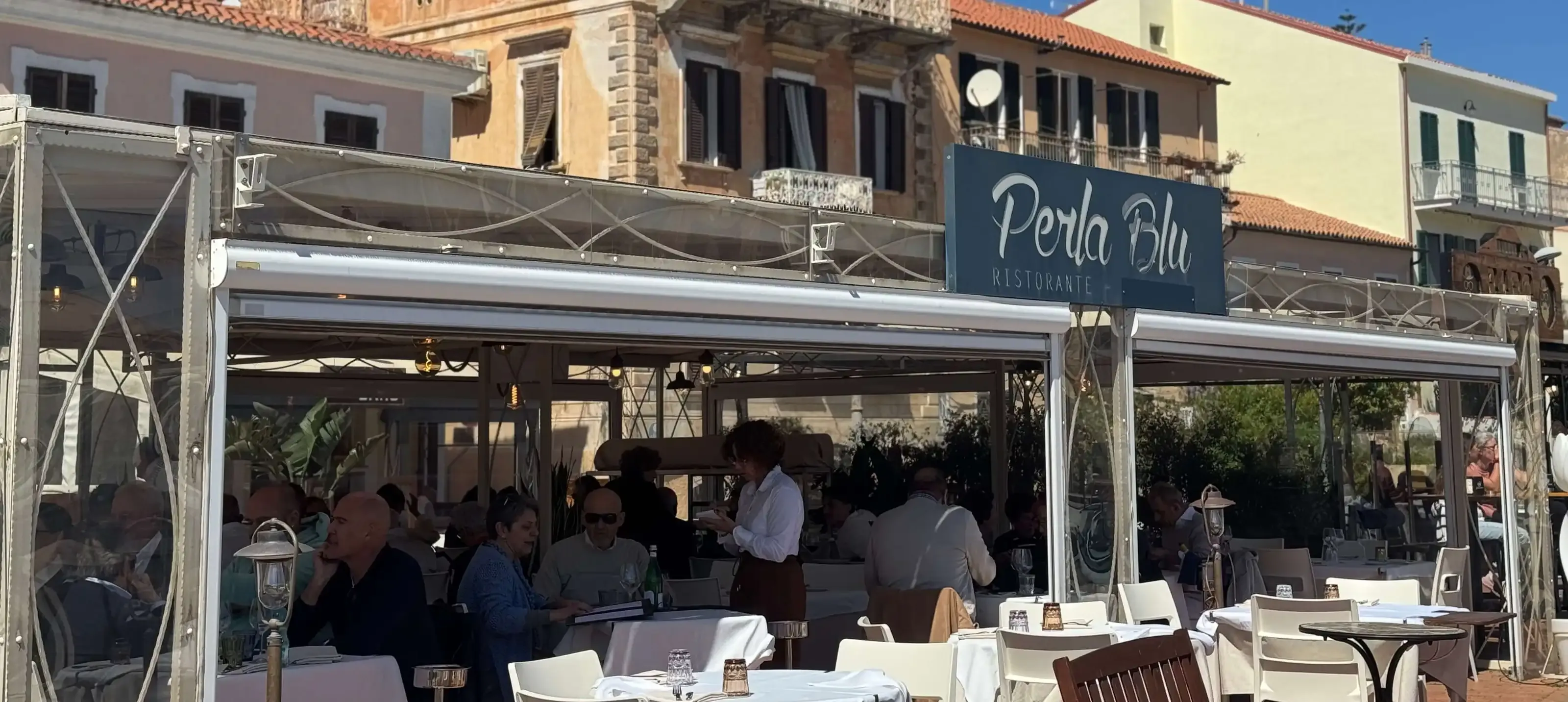 The Ristorante Perla Blu terrace set up for an event, in the evening on Cala Gavetta harbour
